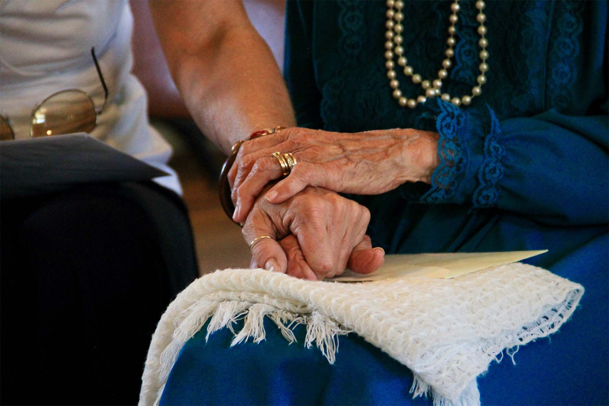 Resident holding carers hand