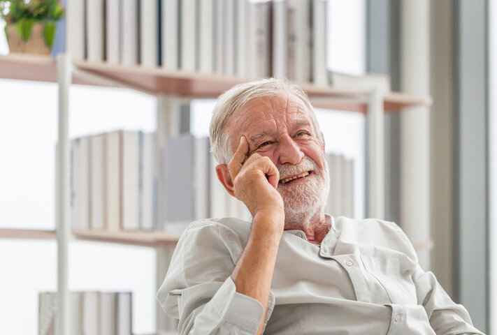 older man smiling in living room of care home