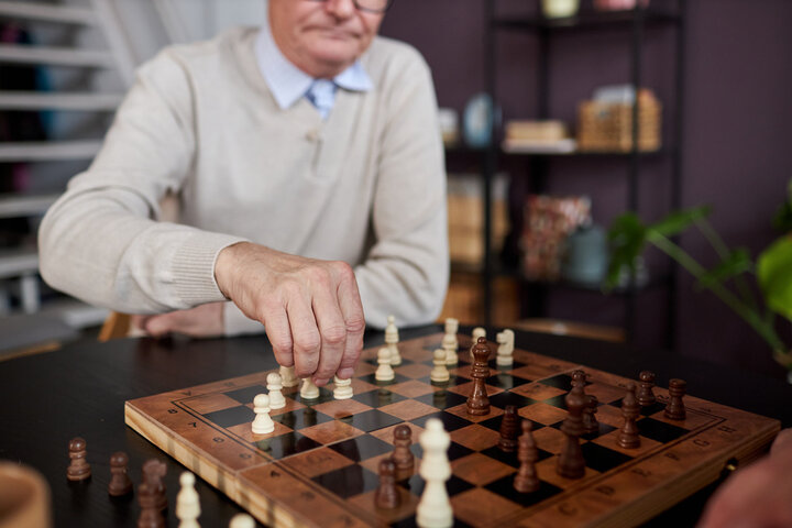 older man playing chess in a care home