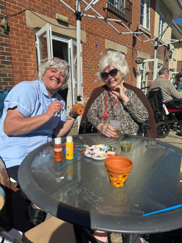residents painting things outside with staff