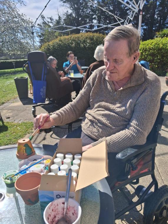 residents painting things outside with staff