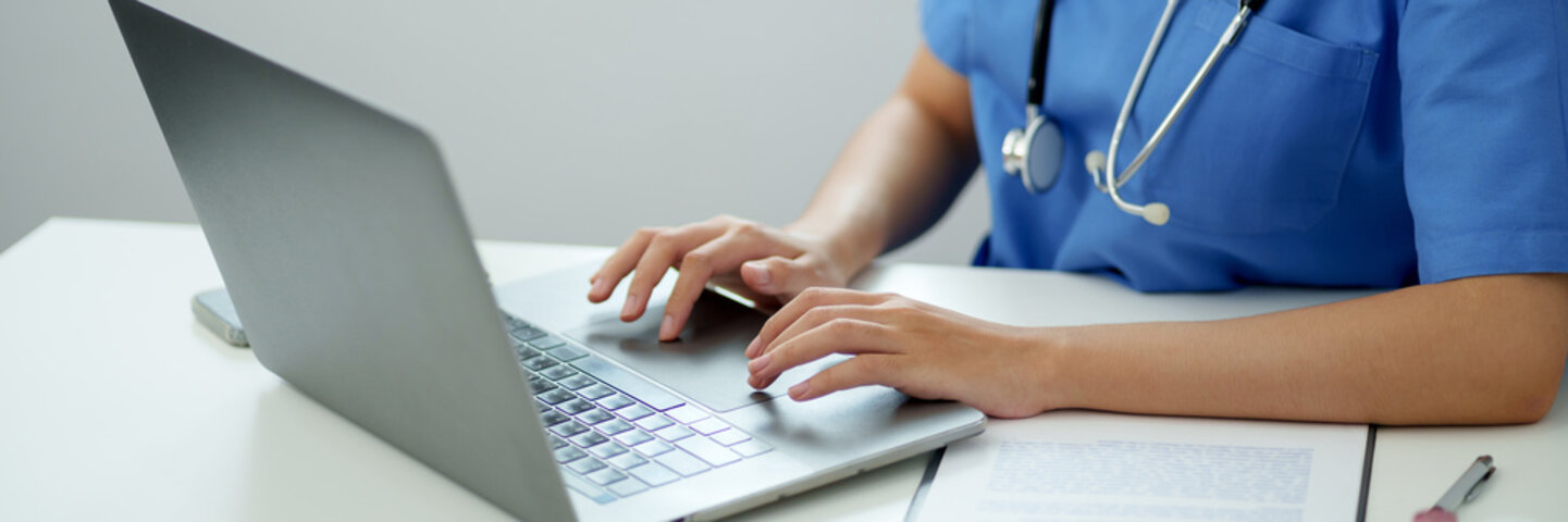 nurse inputting notes to a laptop
