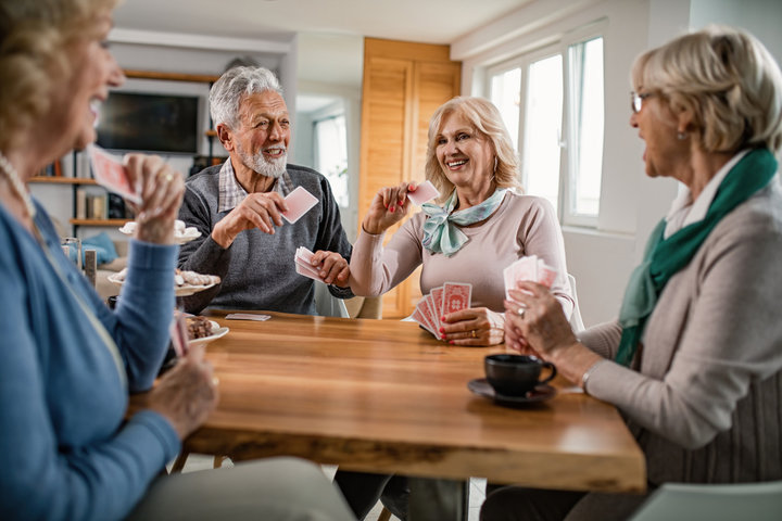 seniors playing cards together in a care home
